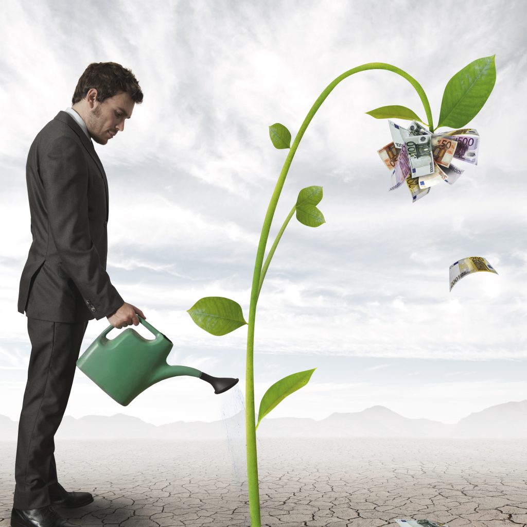 Businessman watering a plant that produces money